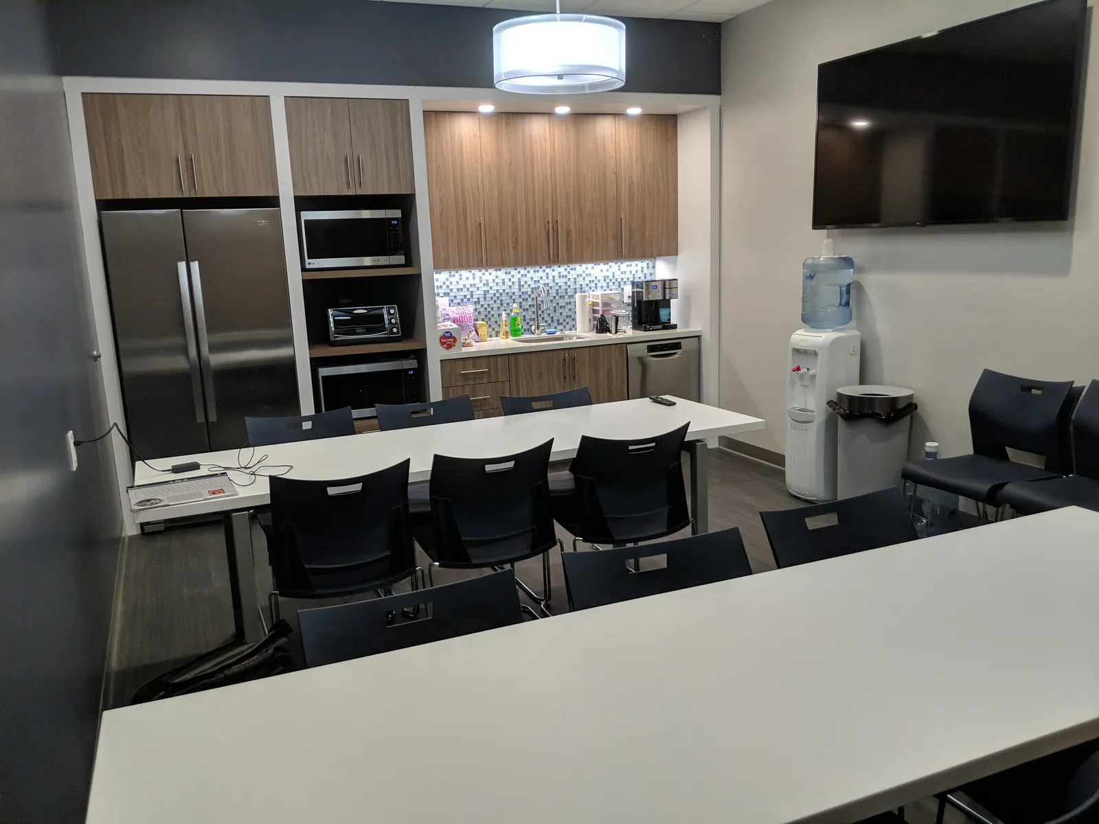 Office kitchen break room with wood cabinetry and stainless appliances.