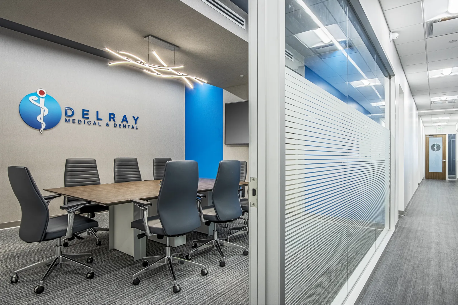 Medical office conference room with glass walls and blue accent column.