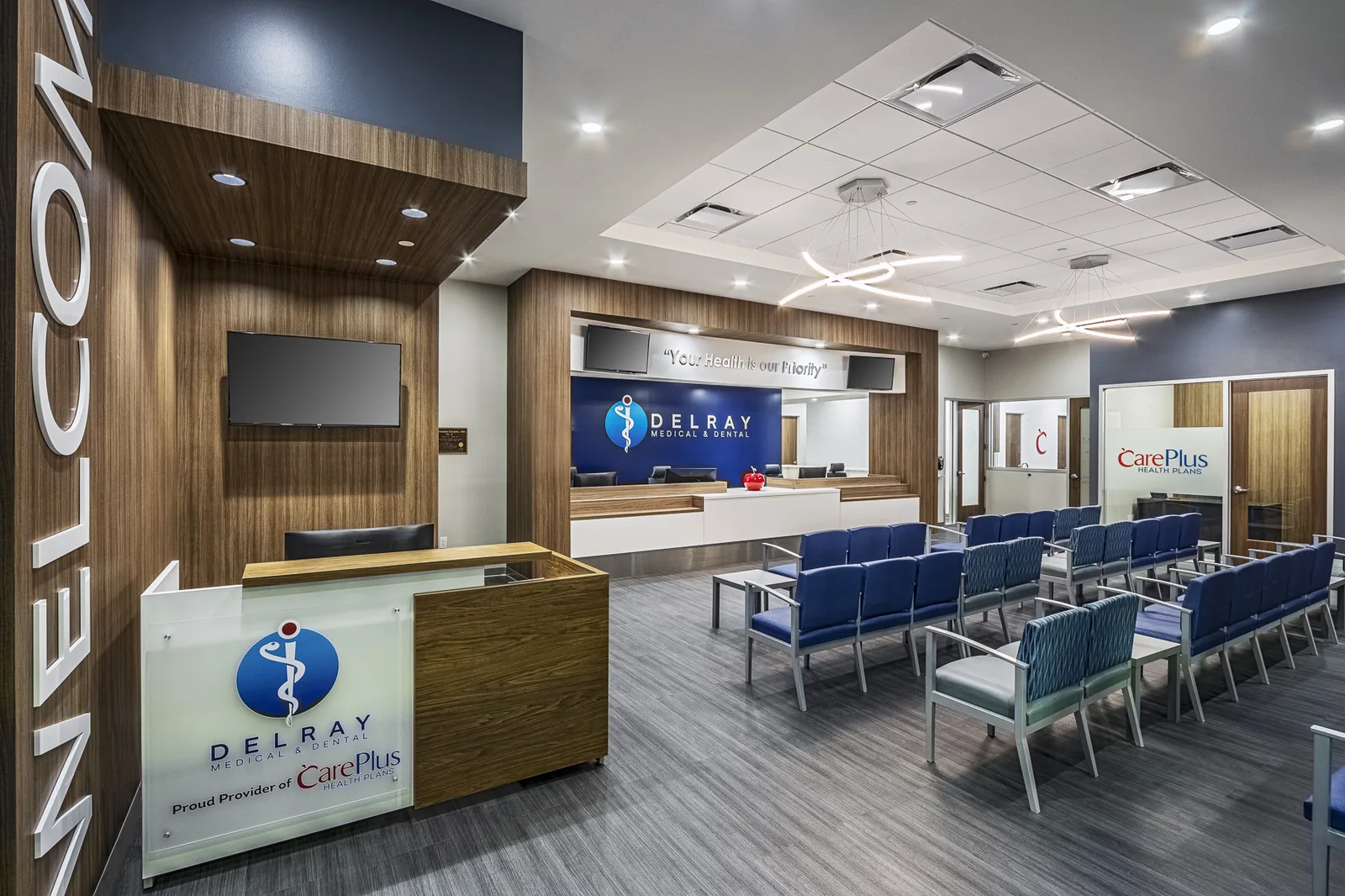 Medical clinic reception with wood paneling, blue accent, and dental branding.